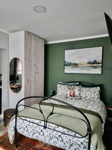a bedroom with a bed with a green wall at Walnut Studio in Clarens
