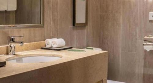 une salle de bain avec un lavabo et un miroir dans l'établissement Jin Jiang Nanjing Hotel, à Nankin