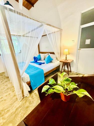 a bedroom with a bed with blue pillows at Coastal Cloud Surf - Walk To Dewata Beach in Unawatuna