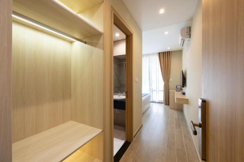 富国Herring Beach Hotel Phu Quoc的有门通往浴室的走廊