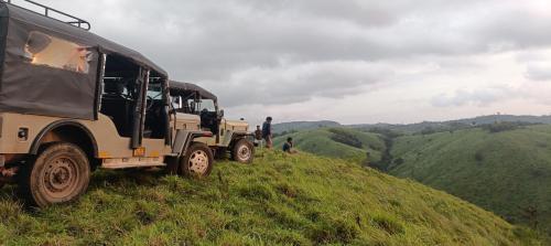 Um caminhão militar estacionado no topo de uma colina gramada. em സ്നേഹ തീരം em Vagamon
