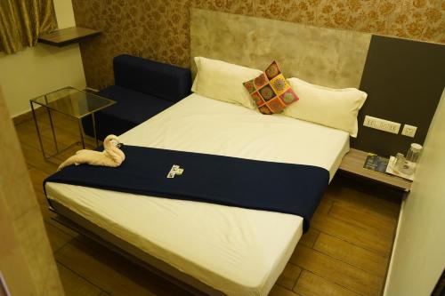 a bed with pillows on it in a room at Alphineglow Hotel in Yercaud