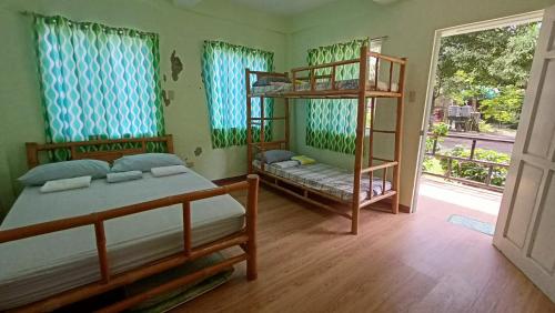 a bedroom with two bunk beds and a balcony at Suki Beach Resort "D" Standard Aircon Room in Santa Magdalena