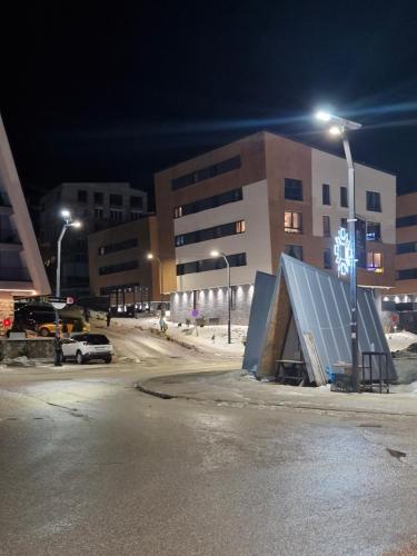 un parking vide avec un bâtiment la nuit dans l'établissement Z apartment, à Trnovo