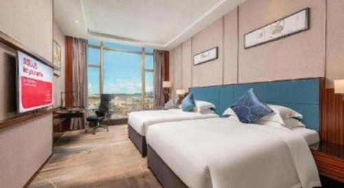 Ένα ή περισσότερα κρεβάτια σε δωμάτιο στο Ramada Foshan Shunde