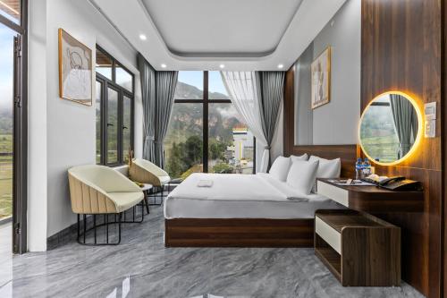 a hotel room with a bed and a desk and chairs at Ha Giang Hill Hotel in Dồng Văn