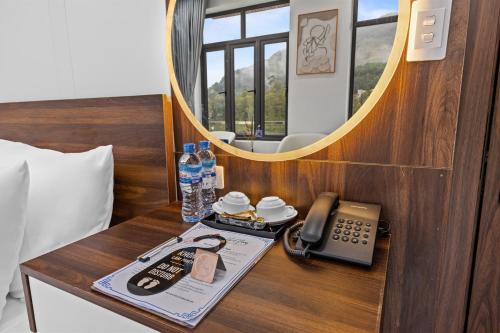 a table with a telephone and a mirror in a room at Ha Giang Hill Hotel in Dồng Văn