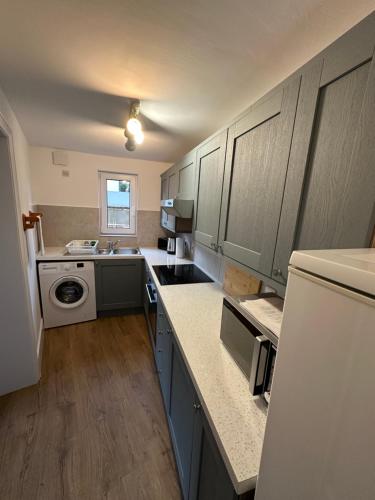 a kitchen with gray cabinets and a white refrigerator at Cherry Tree in Oxford
