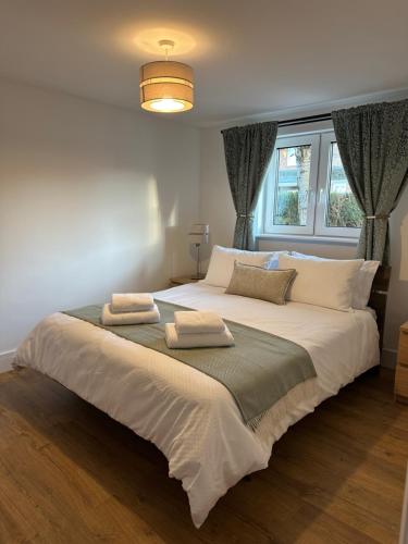 a bedroom with a large bed with two towels on it at Cherry Tree in Oxford