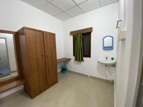 une salle de bain avec un lavabo et un miroir dans l'établissement Dream Valley Resort, à Neil Island