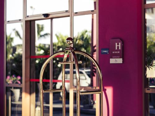 una silla dorada frente a una puerta en Mercure Cayenne Royal Amazonia, en Cayenne