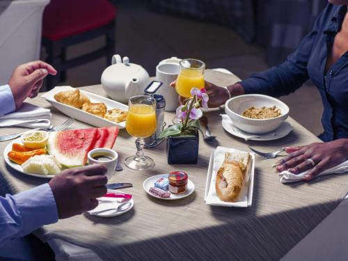 un grupo de personas sentadas en una mesa desayunando en Mercure Cayenne Royal Amazonia, en Cayenne