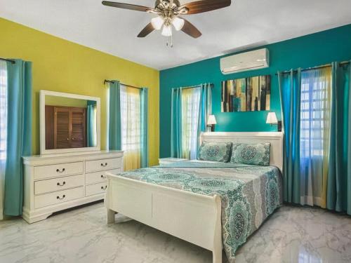 Un dormitorio con una cama y un ventilador de techo. en Tropical paradise, 