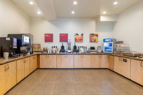 デンバーにあるMainStay Suites Near Denver Downtownの木製のキャビネットとカウンタートップを備えたキッチン