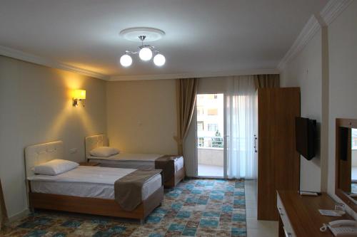 a hotel room with two beds and a television at Deveci Hotel in Mut