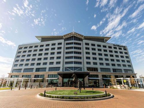 Un gran edificio con una estatua delante. en The William Inglis Mgallery, en Warwick Farm