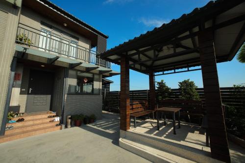 une terrasse couverte d'une maison avec un banc et une terrasse dans l'établissement Happy Together B&B, à Wujie