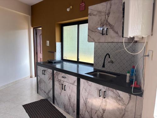 a kitchen with a sink and a counter top at Casa de Aaron in Colva