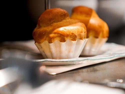 two muffins sitting on a plate on a table at Hôtel Mercure Paris Suresnes Longchamp in Suresnes