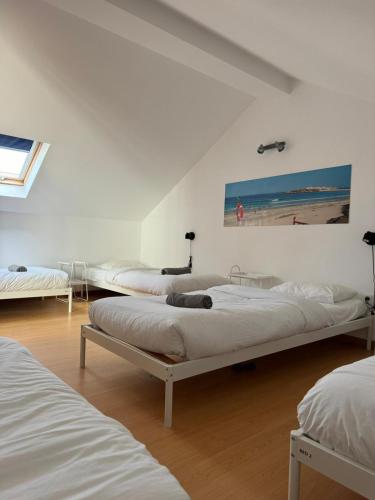 a room with three beds and a window at Baleal GuestHouse - Yoga included in Baleal