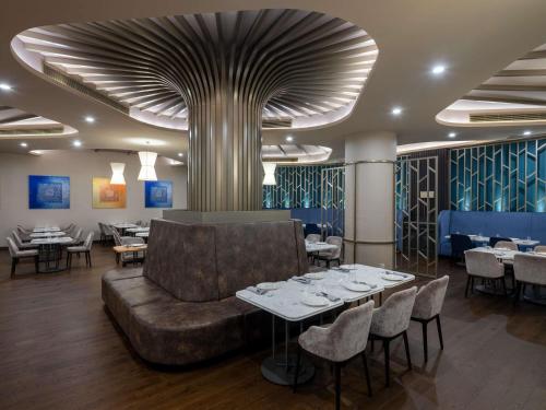 Un restaurante con un sofá, mesas y sillas. en Sofitel Istanbul Taksim, en Estambul