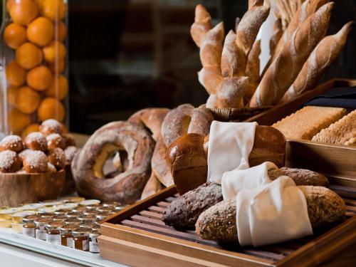 a display case with various types of bread and pastries at Mondrian Doha in Doha