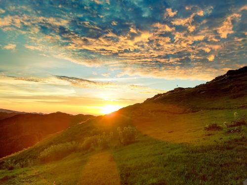 a sunset on a hill with a dirt road at The Royal Roast in Shoja
