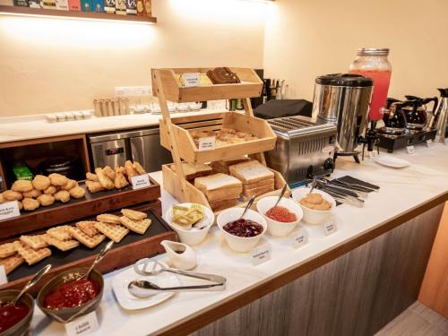a buffet line with pastries and other food items at ibis budget Singapore Imperial in Singapore