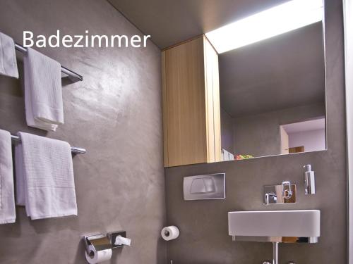 a bathroom with a sink and a mirror and towels at Kartause Ittingen in Warth