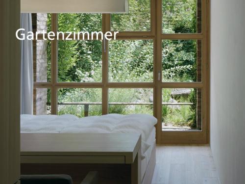 ein Schlafzimmer mit einem Bett und einem großen Fenster in der Unterkunft Kartause Ittingen in Warth