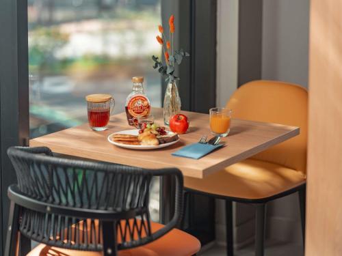 una mesa con un plato de comida y bebidas. en Novotel Paris Val de Fontenay, en Fontenay-sous-Bois