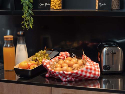 Un bol de fruta en un mostrador con un bol de uvas. en Novotel Paris Val de Fontenay, en Fontenay-sous-Bois