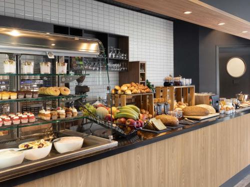 Una línea de buffet con muchos tipos diferentes de comida. en Adagio Antwerp City Center, en Amberes