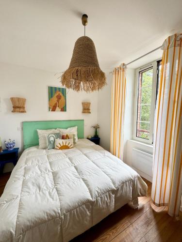 T3 Le Prima - Climatisation - Parking gratuit في بانيير-دوبيغور: غرفة نوم بها سرير كبير وثريا