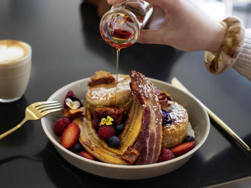 Un tazón de tostadas francesas con fruta y almíbar en Pullman Sydney Penrith, en Penrith