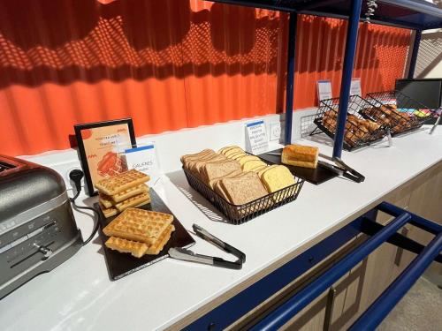 een buffet met brood en wafels op een tafel bij ibis budget Loudéac Vélodrome in Loudéac