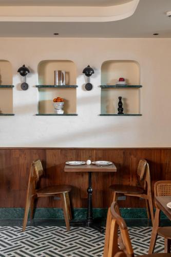 um restaurante com mesas, cadeiras e prateleiras na parede em Abode Jaipur em Jaipur
