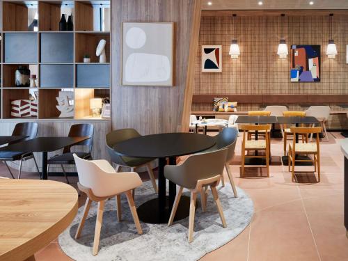 ein Restaurant mit Tischen und Stühlen in einem Raum in der Unterkunft Aparthotel Adagio Original Toulouse Centre La Grave in Toulouse