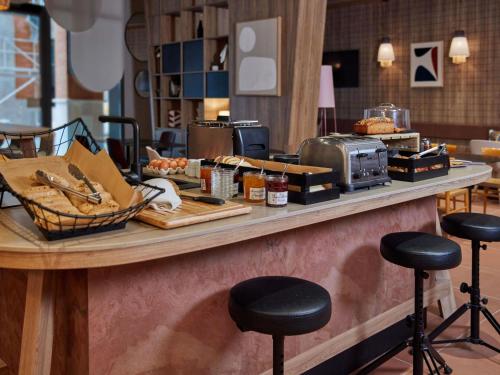a counter with some food on it with stools at Aparthotel Adagio Original Toulouse Centre La Grave in Toulouse