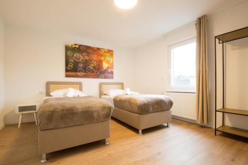 une chambre avec deux lits et une fenêtre dans l'établissement Luxury Ixheim, à Zweibrücken