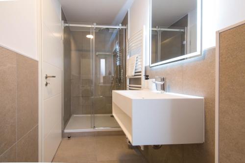 une salle de bain avec un lavabo blanc et une douche dans l'établissement Luxury Ixheim, à Zweibrücken