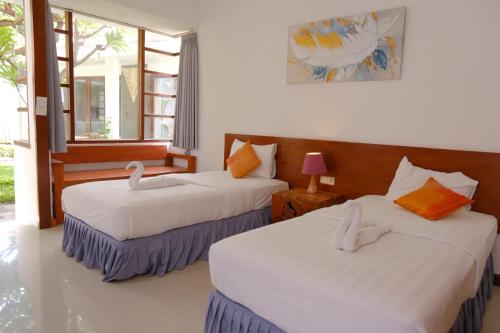 a bedroom with two beds with white sheets at Alba Tulamben in Tulamben