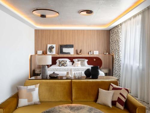 una camera con letto e divano con cuscini di Pullman Lyon a Lione