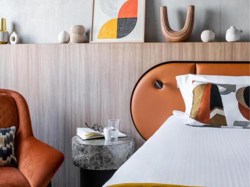 a bedroom with a bed and a chair at Pullman Lyon in Lyon