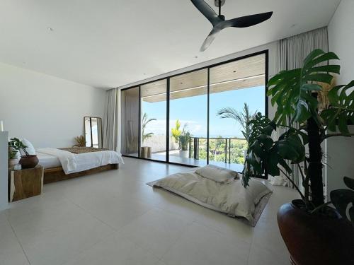 ein Schlafzimmer mit einem Bett und einem großen Fenster in der Unterkunft Villa Vega 3BR Sea View Near Beach in Ungasan