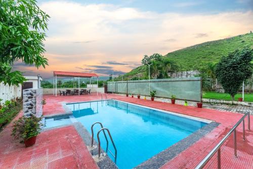 une piscine avec de l'eau bleue dans une cour dans l'établissement Gtn Aranya Villas, à Eklingji