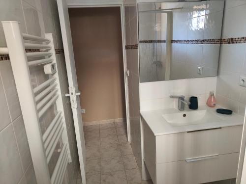 滨海阿热莱斯Charmante Villa de plain pied dans quartier calme的一间白色浴室，配有洗手池和镜子。