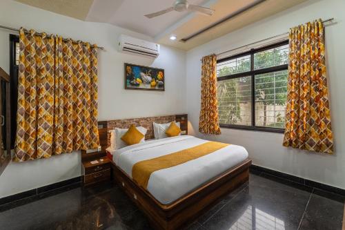 une chambre avec un lit et deux fenêtres dans l'établissement Gtn Aranya Villas, à Eklingji