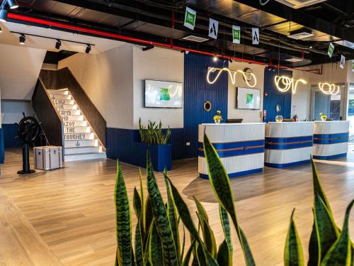 a room with blue and white walls and potted plants at Ibis Styles El Malecon Guayaquil in Guayaquil