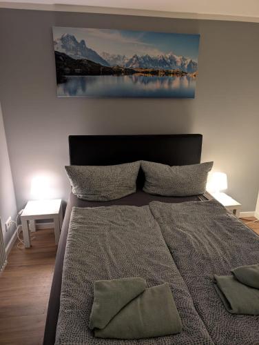 a bedroom with a bed with a painting on the wall at Stadtnah an der Förde 5704 in Flensburg